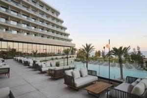 a hotel patio with couches and a swimming pool at Sunrise Emerald in Protaras