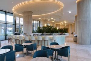a hotel lobby with tables and chairs and a bar at Sunrise Emerald in Protaras