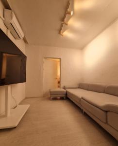 a living room with a couch and a flat screen tv at 4 Beds Busan Gwangalli Big Star Stay in Busan