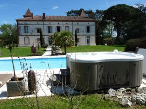 a bath tub sitting in the grass next to a house at Manoir des Chanterelles in Meauzac