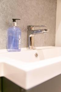 a soap bottle sitting on top of a bathroom sink at Self-contained flat in Girton +36 photos