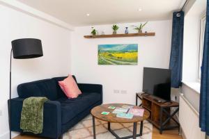 a living room with a blue couch and a table at Self-contained flat in Girton