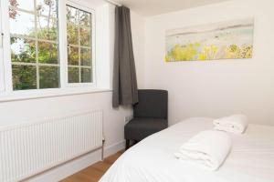 a bedroom with a bed and a chair and a window at Self-contained flat in Girton