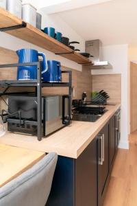 a kitchen with a counter with blue dishes on it at Self-contained flat in Girton