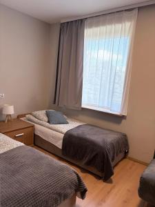 two beds in a bedroom with a window at VillaAnita in Augustów