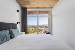 a bedroom with a bed and a large window at Colina do Sol 2 in Amoreira +21 photos