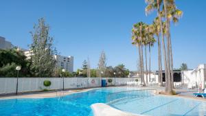 una piscina con palme e una recinzione di BLUESEA Gran Playa a Sa Coma Altre 46 foto