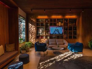 a living room with a couch and chairs and a tv at Novotel Convention And Spa in Antananarivo