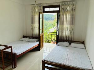 two beds in a room with a window at Cloud Nine in Diyatalawa
