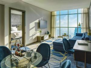 a living room with a couch and chairs in a hotel room at Pullman Sharjah in Sharjah