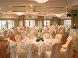 a banquet hall with white tables and white chairs at Mövenpick Hotel Izmir in İzmir