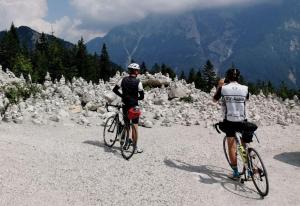 two people riding bikes on a mountain road at Rooms Malina I Peaceful Stay Near Bled & Mountain Views in Blejska Dobrava