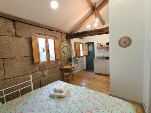 a bedroom with a bed in a room with a kitchen at 4 Soles in Puente Caldelas