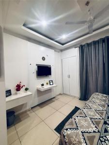 a bedroom with a bed and a tv on the ceiling at Saffron Nest in Zirakpur