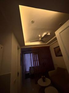 a living room with a ceiling with a window at Saffron Nest in Zirakpur