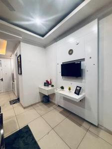 a bathroom with a sink and a tv on the wall at Saffron Nest in Zirakpur