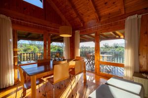 a dining room with a table and chairs and a balcony at Reflections Eco-Reserve in Wilderness