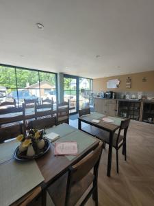 a dining room with tables and chairs and a kitchen at Vaerthof in Diepenbeek