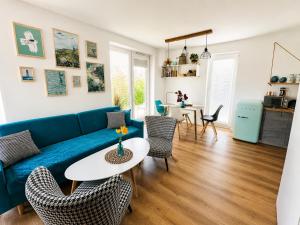 a living room with a blue couch and chairs at Apartament Vespa in Mechelinki