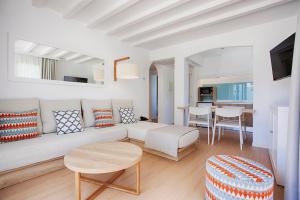 a living room with a couch and a table at Grupotel Aldea Cala'n Bosch in Cala en Bosc