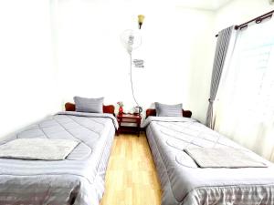 two twin beds in a room with a window at Pkar Thmor Siem Reap Guest House in Phumĭ Réach Born (2) +5 photos