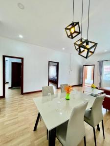 a dining room with a white table and chairs at Pkar Thmor Siem Reap Guest House in Phumĭ Réach Born (2)