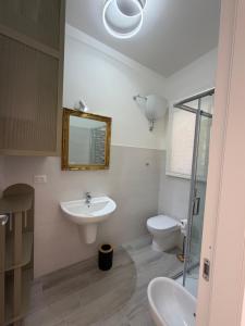 a bathroom with a sink and a toilet and a mirror at Casa Cloe in LʼAquila