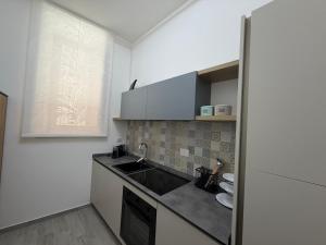 a small kitchen with a sink and a refrigerator at Casa Cloe in LʼAquila