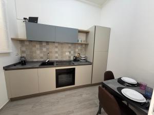 a kitchen with a sink and a refrigerator and a table at Casa Cloe in LʼAquila +20 photos