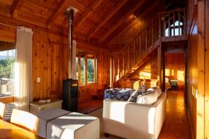 a living room with a white couch and a staircase at Reflections Eco-Reserve in Wilderness