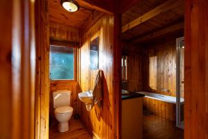 a bathroom with a toilet and a sink and a tub at Reflections Eco-Reserve in Wilderness