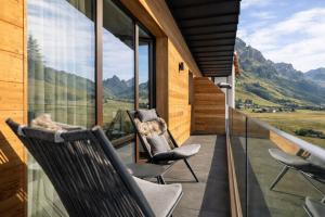 two chairs on a balcony with a view of mountains at Albergo Vezzana in Passo Rolle