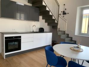 a kitchen with a table and blue chairs at Spazio Perlasca Apt 4 - Cernobbio Como Lake in Cernobbio