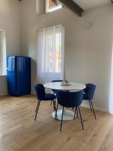 a table and chairs in a room with a blue refrigerator at Spazio Perlasca Apt 4 - Cernobbio Como Lake in Cernobbio +3 photos