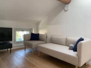 a living room with a white couch and a chair at Spazio Perlasca Apt 4 - Cernobbio Como Lake in Cernobbio
