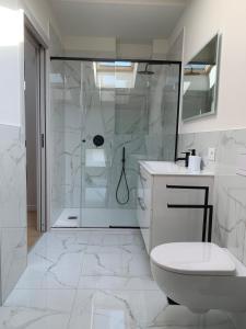 a white bathroom with a shower and a toilet at Spazio Perlasca Apt 4 - Cernobbio Como Lake in Cernobbio