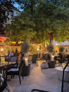 a patio with tables and chairs and a tree at Posthotel Arnold in Gunzenhausen +99 photos