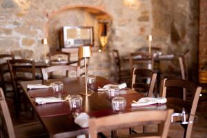 a dining room with wooden tables and chairs and a fireplace at Antico Borgo B&B Seggiano in Seggiano +50 photos