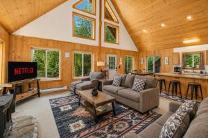 a living room with couches and a tv and a kitchen at Pine River Retreat in Leavenworth
