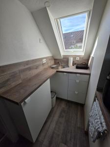 a small kitchen with a sink and a window at Ferienwohnung Bruhn in Meldorf
