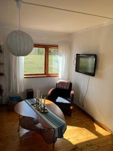 a living room with a table and a tv at Svens Stuga in Burträsk
