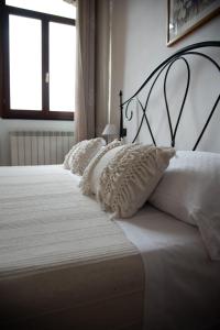 a white bed with white pillows on it with a window at Villa Govi in Diano Castello +2 photos