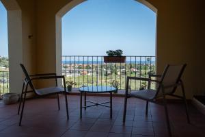a room with two chairs and a table and a window at Villa Govi in Diano Castello