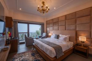 a bedroom with a large bed and a chandelier at Dharohar Retreat, Mukteshwar in Mukteshwar