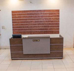 a reception desk in front of a brick wall at NIF-UR Hotel Bohicon in Bohicon