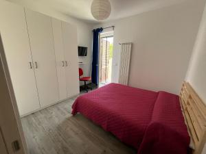 a bedroom with a bed with a red bedspread at Casa Fellini - Giardino e parcheggio gratuito in Venturina Terme