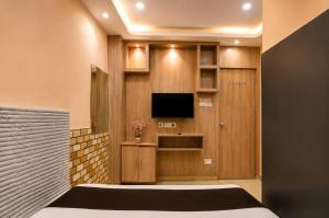 a bedroom with a tv in a wooden wall at Saba Guest House in Kolkata