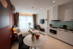 a room with a bed and a table and a kitchen at Centraltique Veranda Living in Hanoi