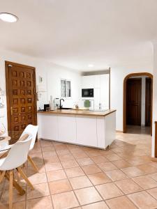 a kitchen with white cabinets and a tile floor at El Mar in San Agustin
