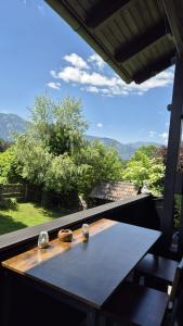 a table on a balcony with a view of the mountains at Wasser & Bergwelt Appartement Kärnten in Seeboden
